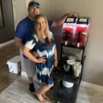 Texas Frozen Tropics owners standing next to a frozen margarita machine rental