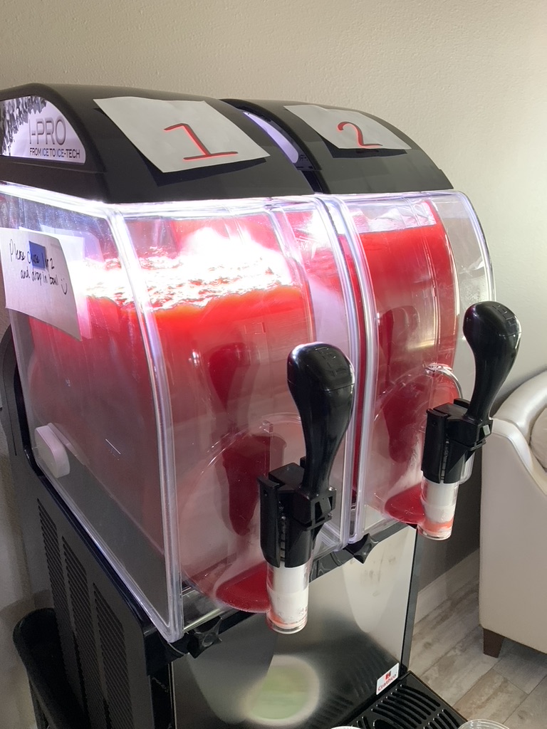 Close-up of a Texas Frozen Tropics frozen margarita machine with red flavor mix