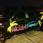 Texas Frozen Tropics truck with neon-lit graphics at night