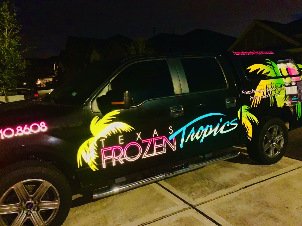 Texas Frozen Tropics truck with neon-lit graphics at night