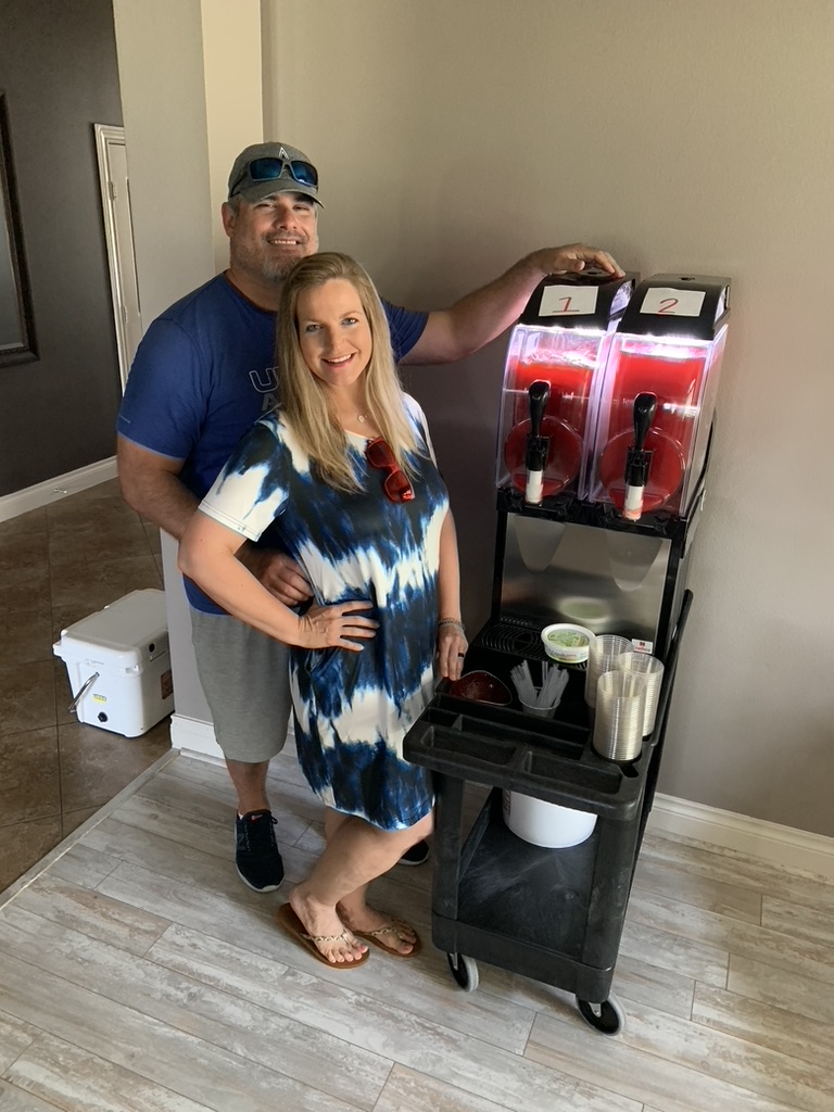Texas Frozen Tropics owners standing next to a frozen margarita machine rental